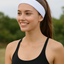Woman in black athletic wear with a white headband outdoors